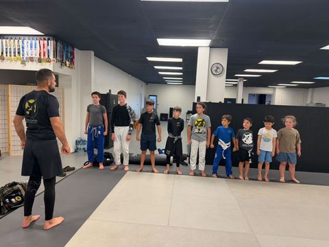 Kids & Teen BJJ students lined up for a No-Gi class with their instructor